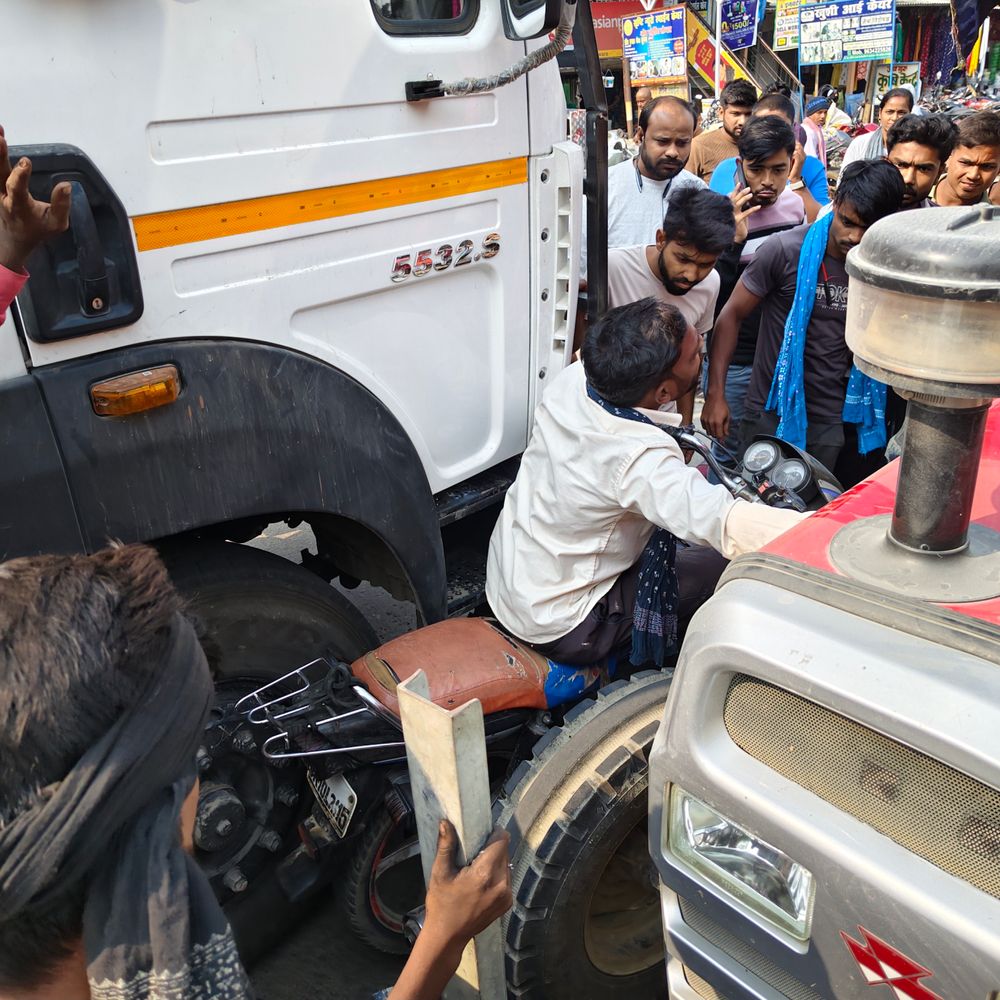 सन्हौला बाजार में बाइक सवार बाल-बाल बचा:ट्रैक्टर और ट्रक के बीच फंसी मोटर साइकिल, मौके पर लोगों ने बचाई जान